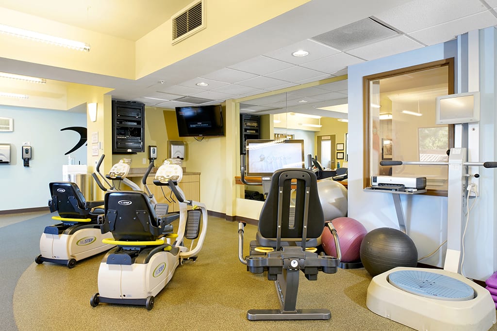 A well-equipped gym with cardio machines and exercise equipment.