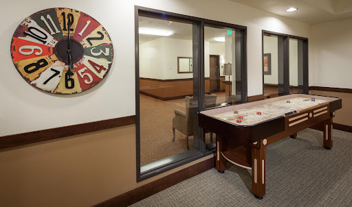 A view of a recreational area featuring a shuffleboard table and a colorful wheel.