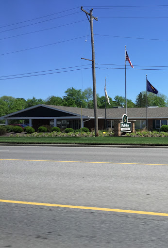 A view of a building with flags in front, set against a clear blue sky.