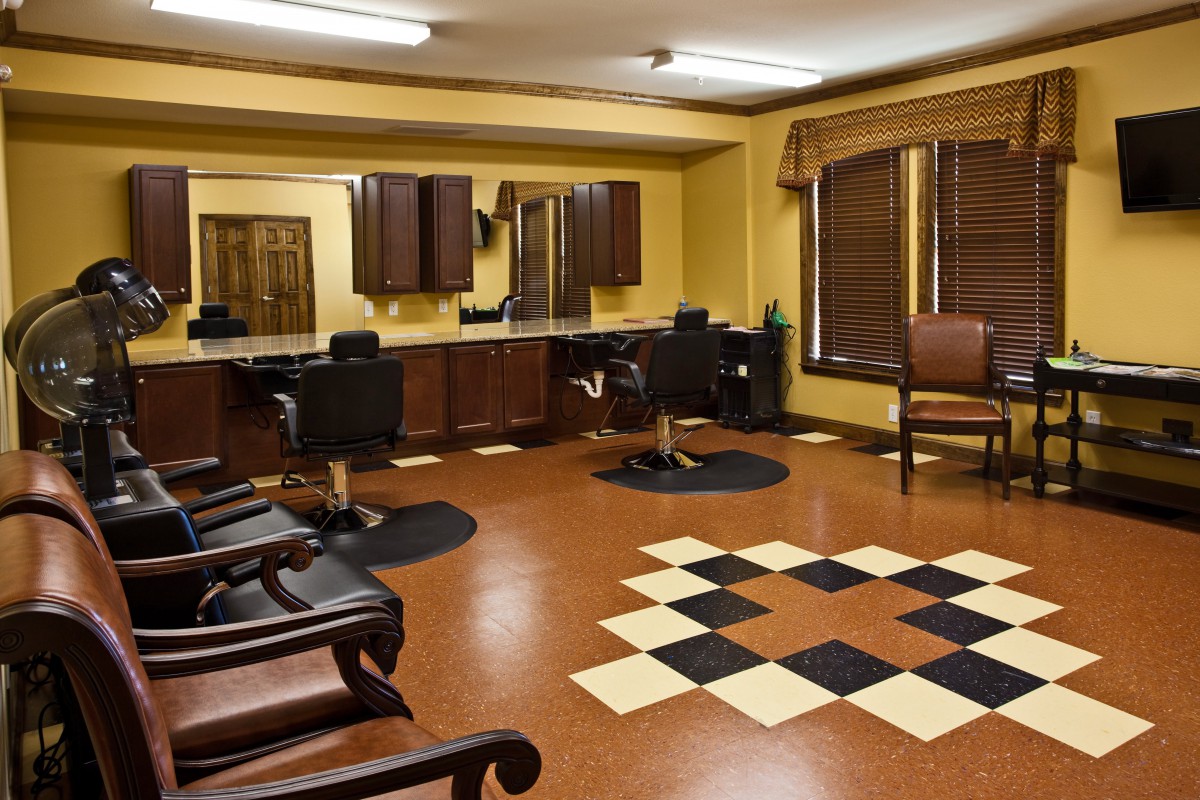 A tidy and well-organized hair salon interior with multiple barber chairs, mirrors, and a distinct floor pattern.