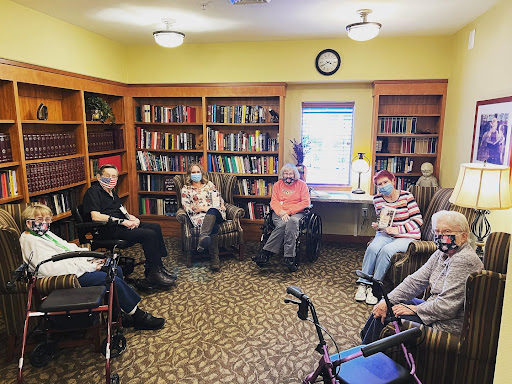 A group of seniors gathered in a library for an engaging reading session.
