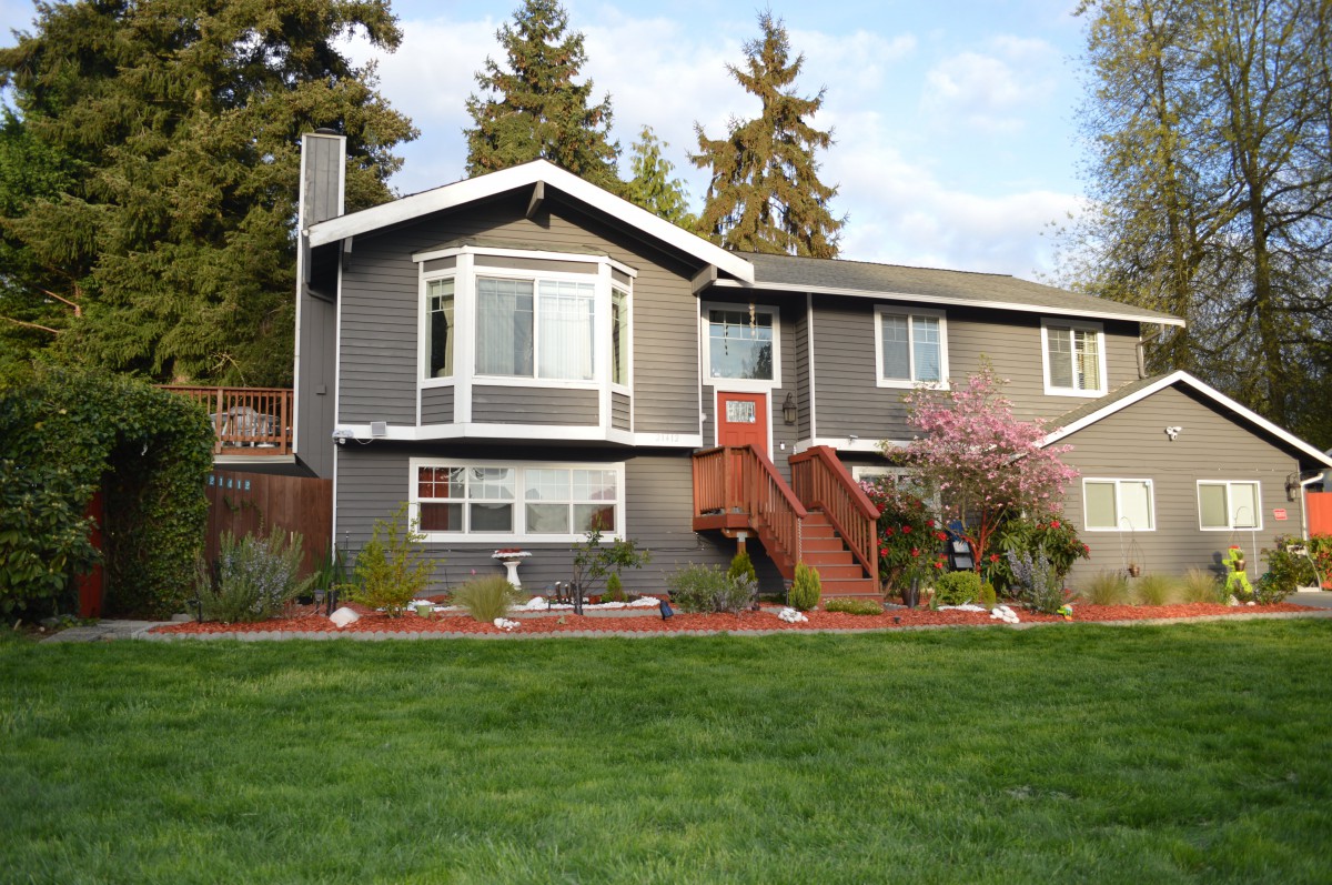 A suburban house with a landscaped yard and surrounding trees.