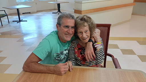 A heartfelt moment shared between a man and an elderly woman, capturing joy and connection.