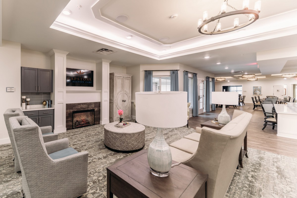 A modern living room with stylish furniture, a fireplace, and elegant lighting.