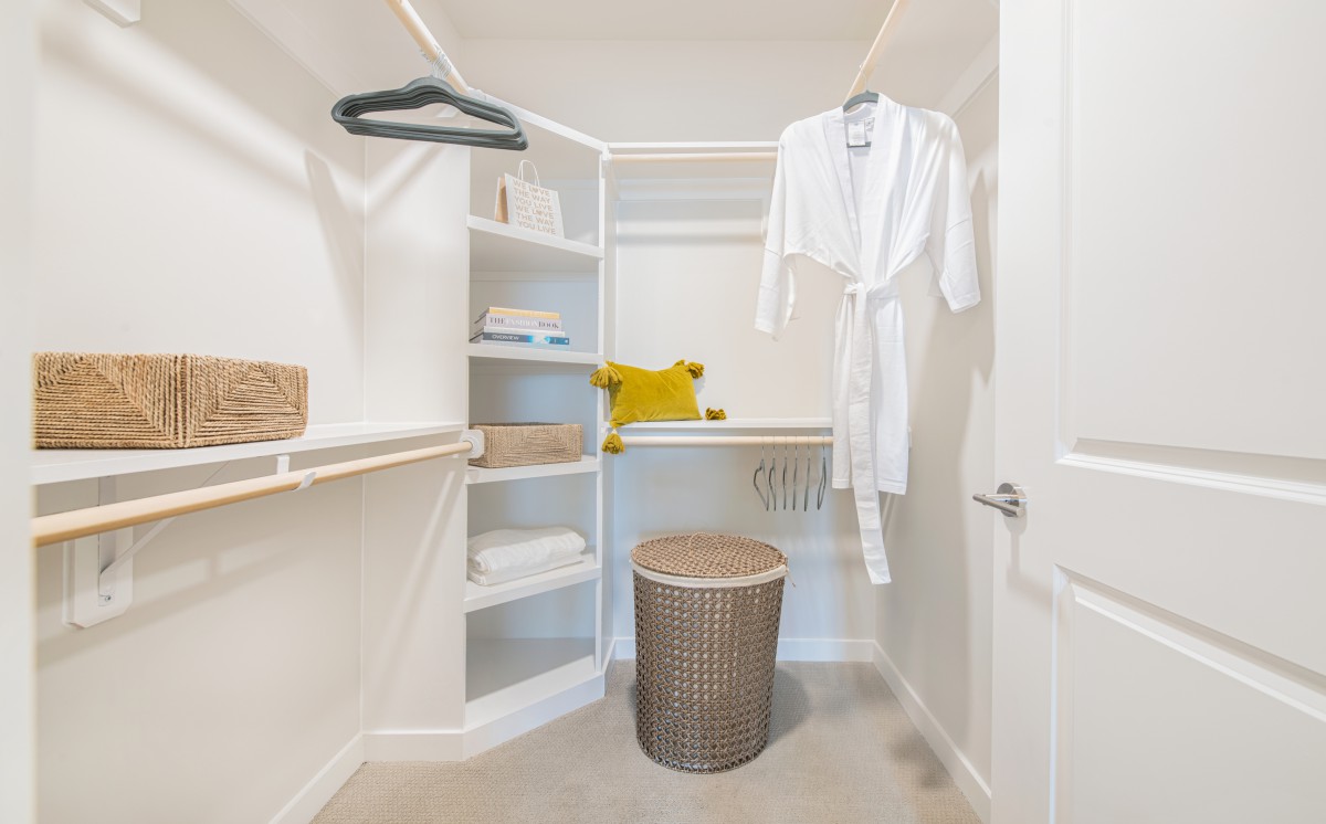 A neatly organized closet with shelves, hangers, and a wicker basket.