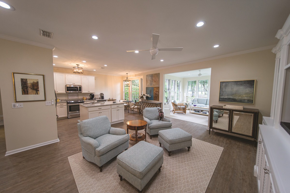 A spacious open-concept living room and kitchen area with modern furnishings and cozy seating.