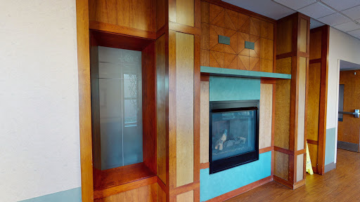 A beautifully designed interior featuring a modern fireplace with vibrant blue accents and elegant wood paneling.
