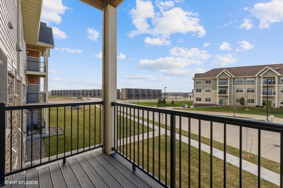 A suburban balcony overlooking a residential neighborhood with clear skies.