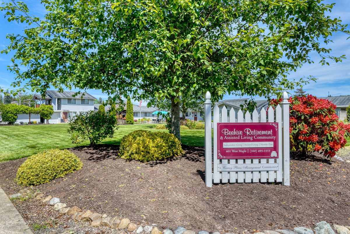 A well-maintained yard with a real estate sign in front of a house.