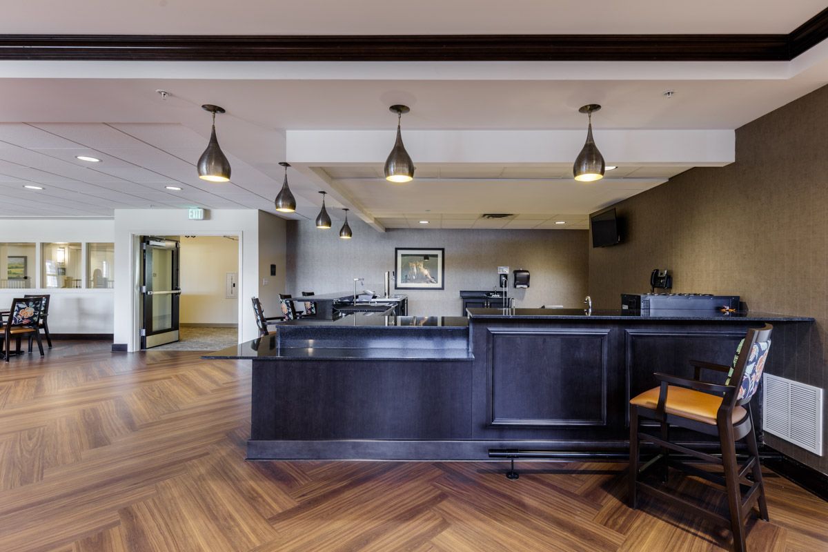 A modern lobby area featuring a reception desk, elegant lighting, and wood flooring.