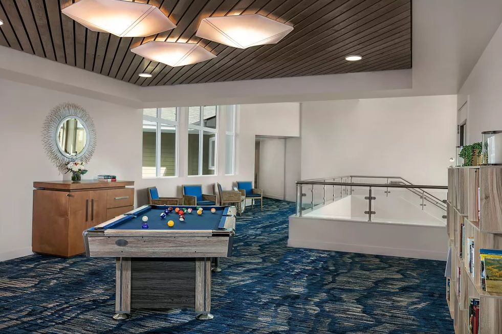 A modern recreation area featuring a billiard table and comfortable seating.