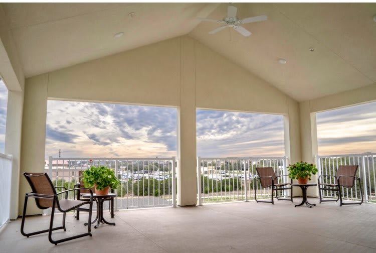 Spacious balcony with seating and scenic sky view.