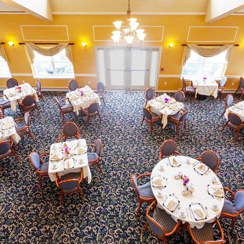 An elegant dining room setup with round tables, chairs, and decorative table settings.