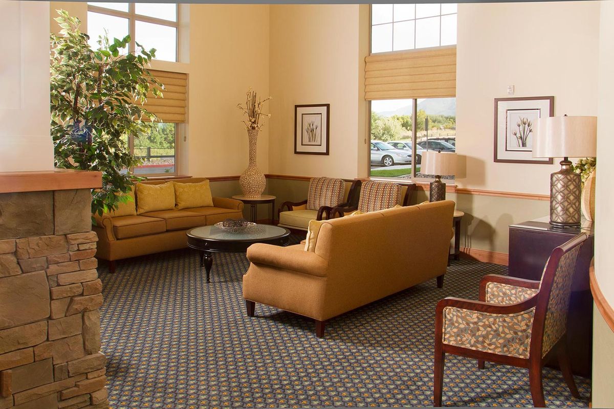 A cozy lobby area with comfortable sofas and a large window.