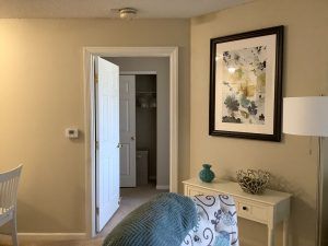 A cozy interior space featuring a doorway, wall artwork, and a small table with decorative items.