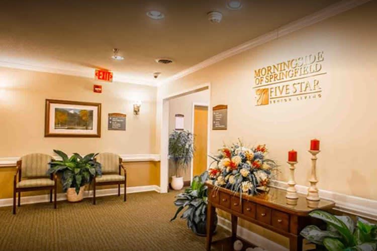 A well-decorated lobby area featuring floral arrangements, seating, and warm lighting.