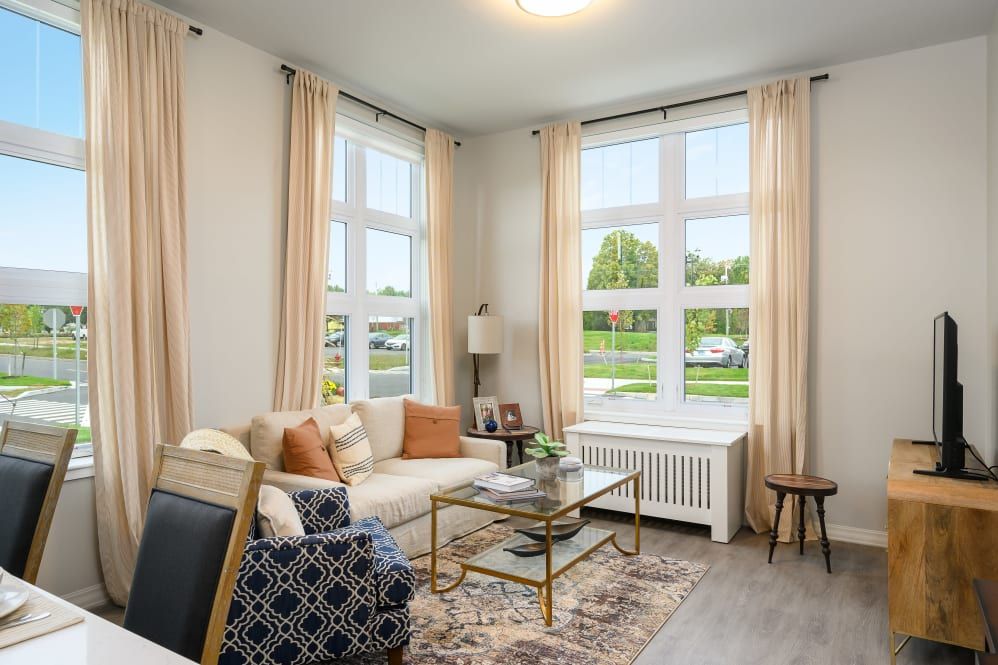 A cozy, well-lit living room with a comfortable sofa and large windows.