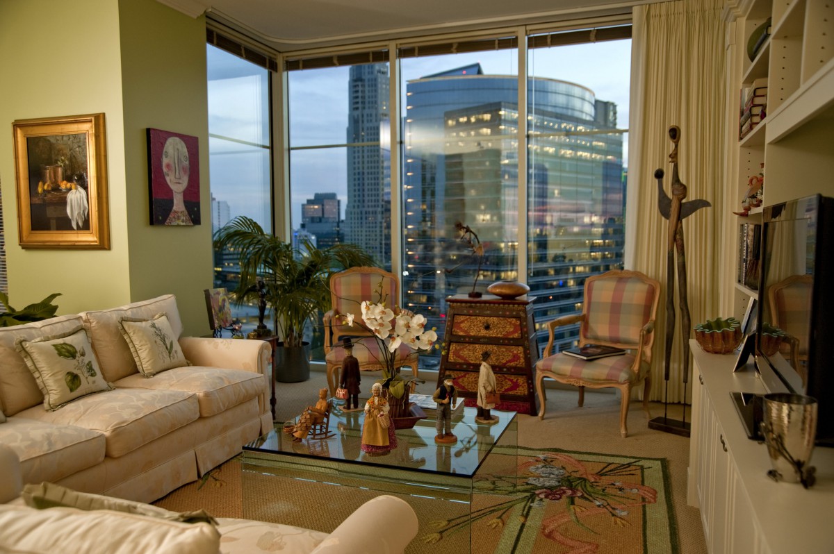 A modern living room with a stunning city view through large glass windows.