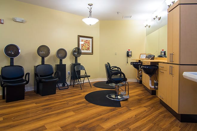 A modern beauty salon with hairdryers, chairs, and a mirrored workstation.