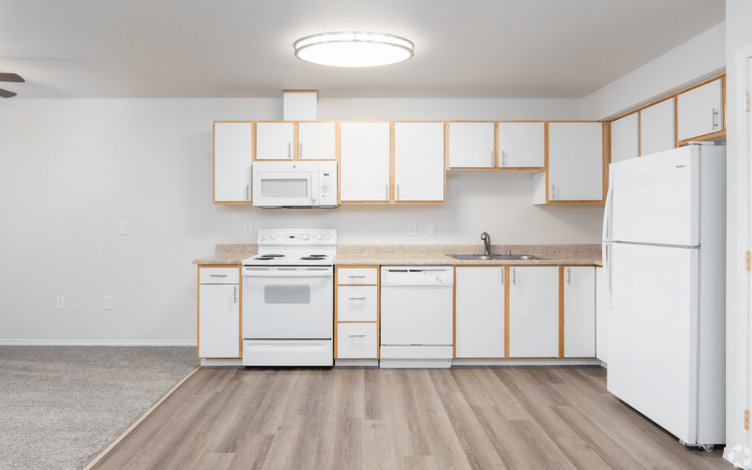 A modern kitchen with white cabinets and essential appliances.