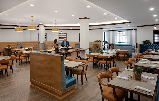 A modern dining interior with wooden furniture and a well-lit atmosphere.