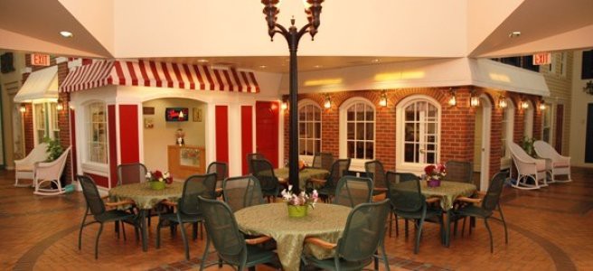 A cozy indoor seating area with tables and chairs, featuring decorative lighting and a charming atmosphere reminiscent of a cafe or restaurant.
