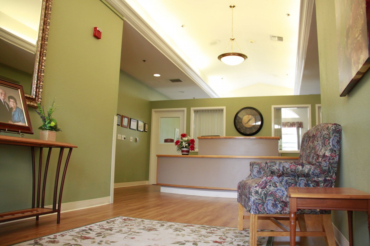 A cozy reception area with green walls and comfortable seating.