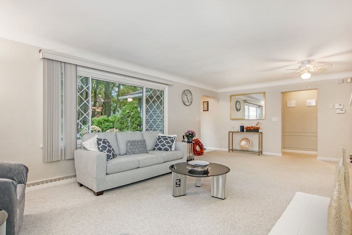 A bright and spacious living room with a sofa, coffee table, and large window.