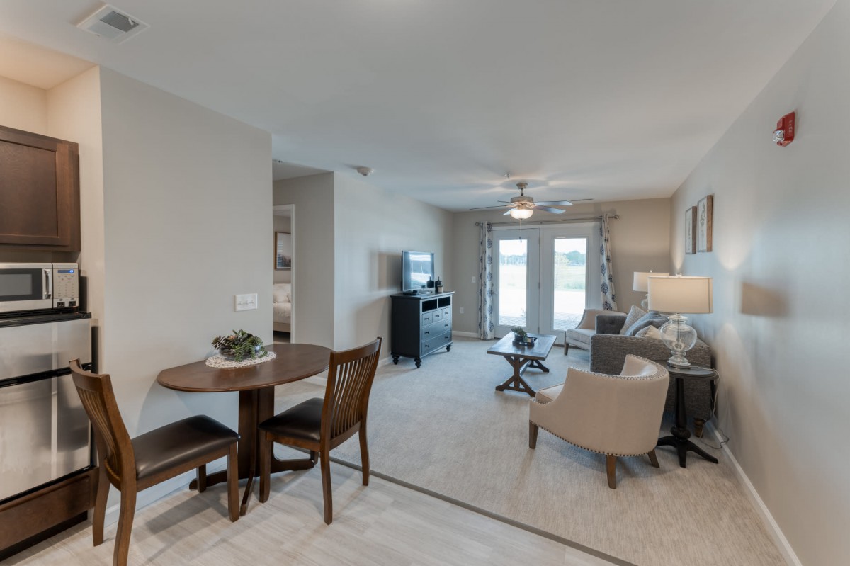 A modern apartment living space with a cozy dining area and comfortable seating.