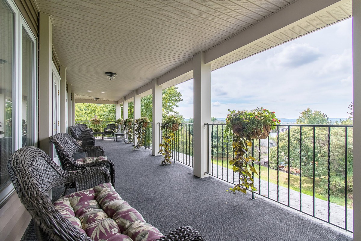 A spacious porch with comfortable seating and a view of the surrounding landscape.