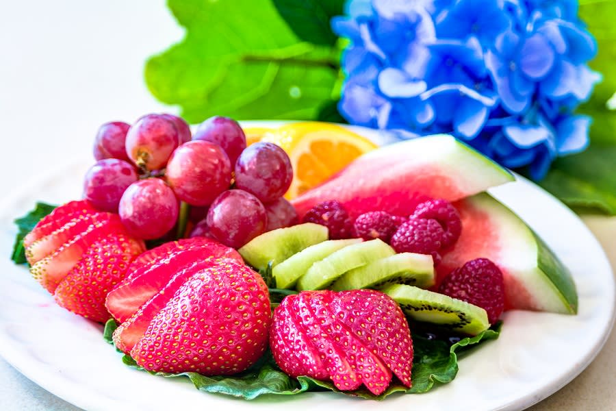 A vibrant assortment of fresh fruits including strawberries, grapes, kiwi, raspberries, watermelon, and an orange slice.