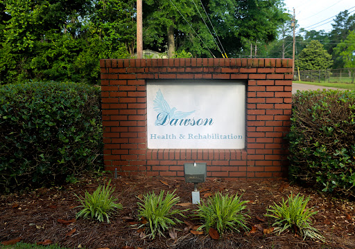 A welcoming sign for a location named 'Dawson' surrounded by lush greenery.