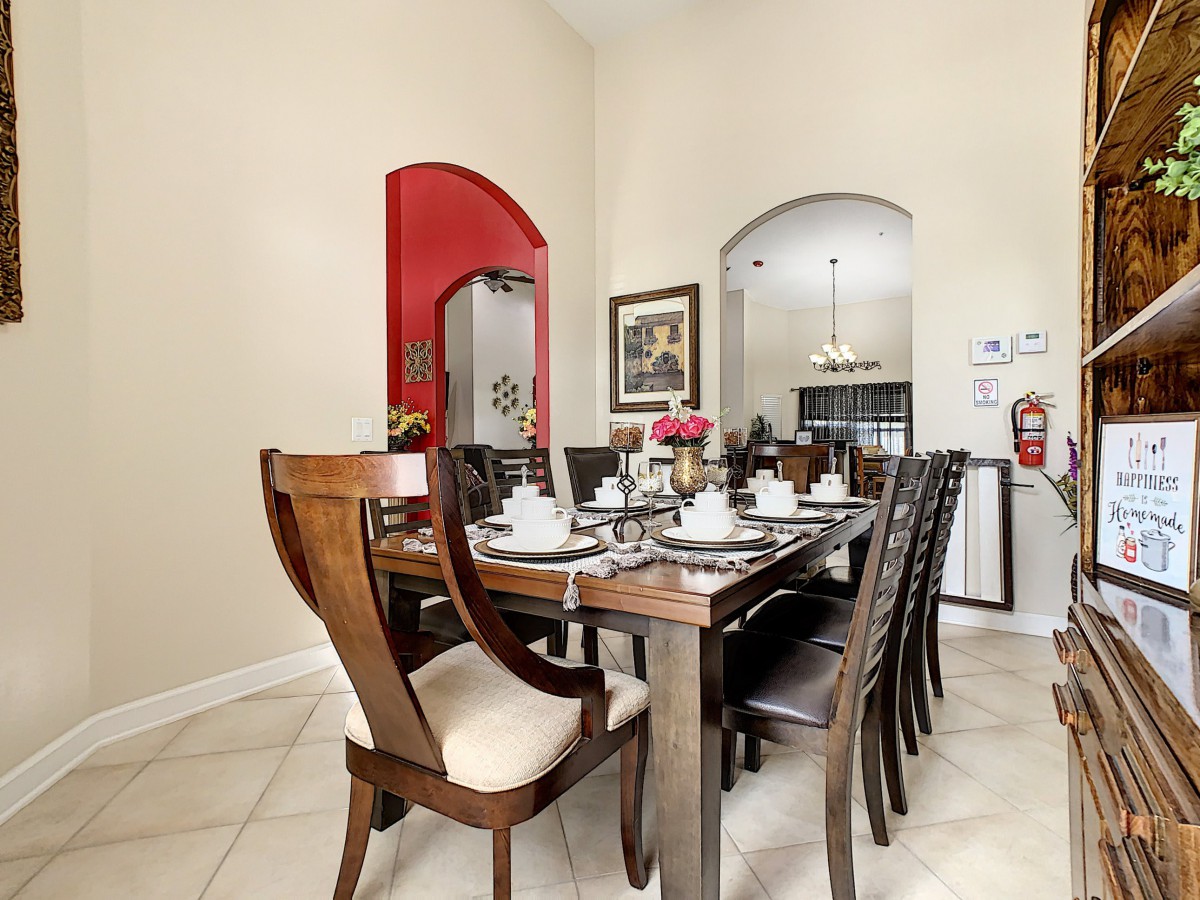 A modern dining room with a wooden table set for a meal, surrounded by stylish chairs and featuring elegant interior design.