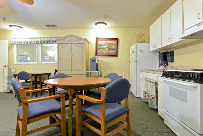 A cozy kitchen and dining area with a round table, chairs, and essential appliances.