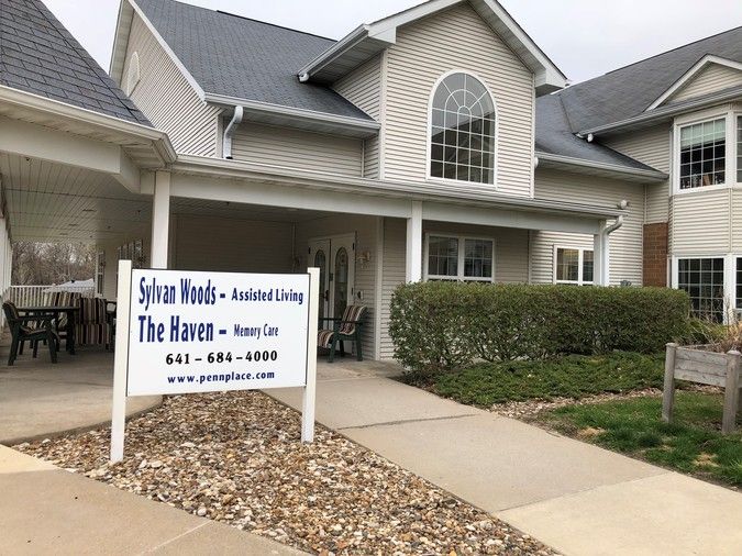 Front view of an assisted living facility with a sign out front.
