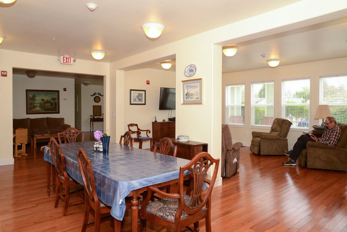 A cozy dining and living area with wooden flooring and classic furniture.