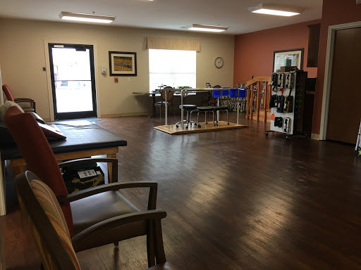 A spacious waiting area with wooden flooring and ample natural light.