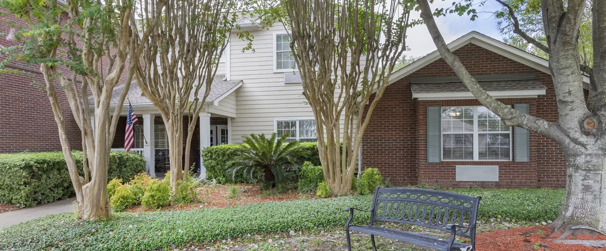 A cozy residential house with well-maintained garden and a bench for relaxation.