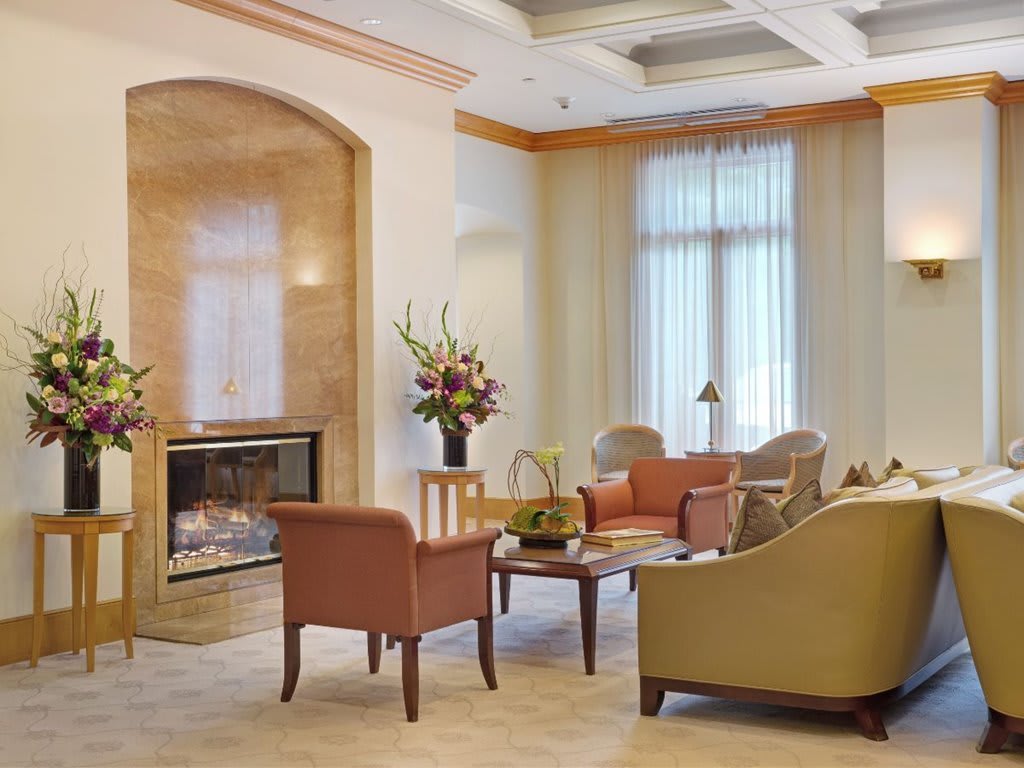 A cozy and elegant living room with comfortable seating around a fireplace.