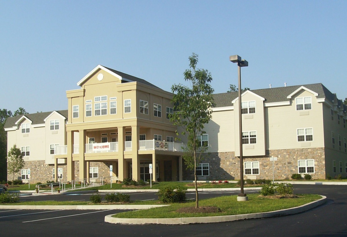 A modern residential apartment complex with a landscaped entrance.