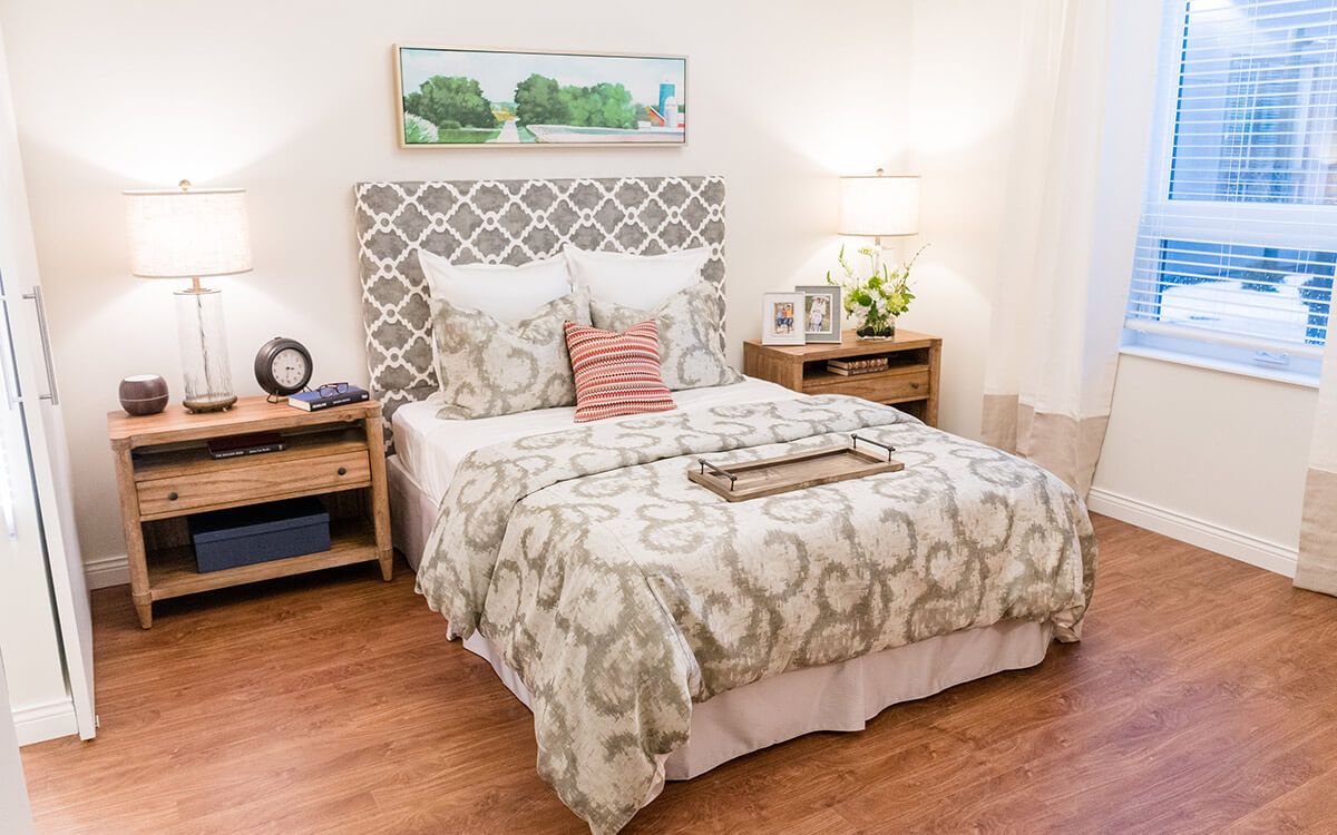 A cozy bedroom with elegant bedding and wooden furniture.