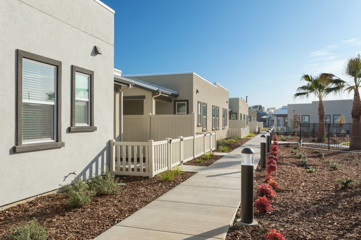 Modern residential housing with a well-maintained walkway and landscaping.