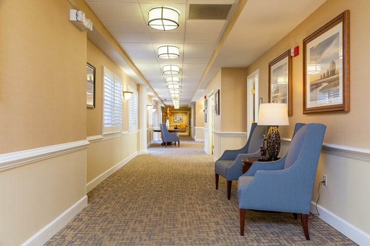 A well-lit hallway with blue chairs and decorative elements.