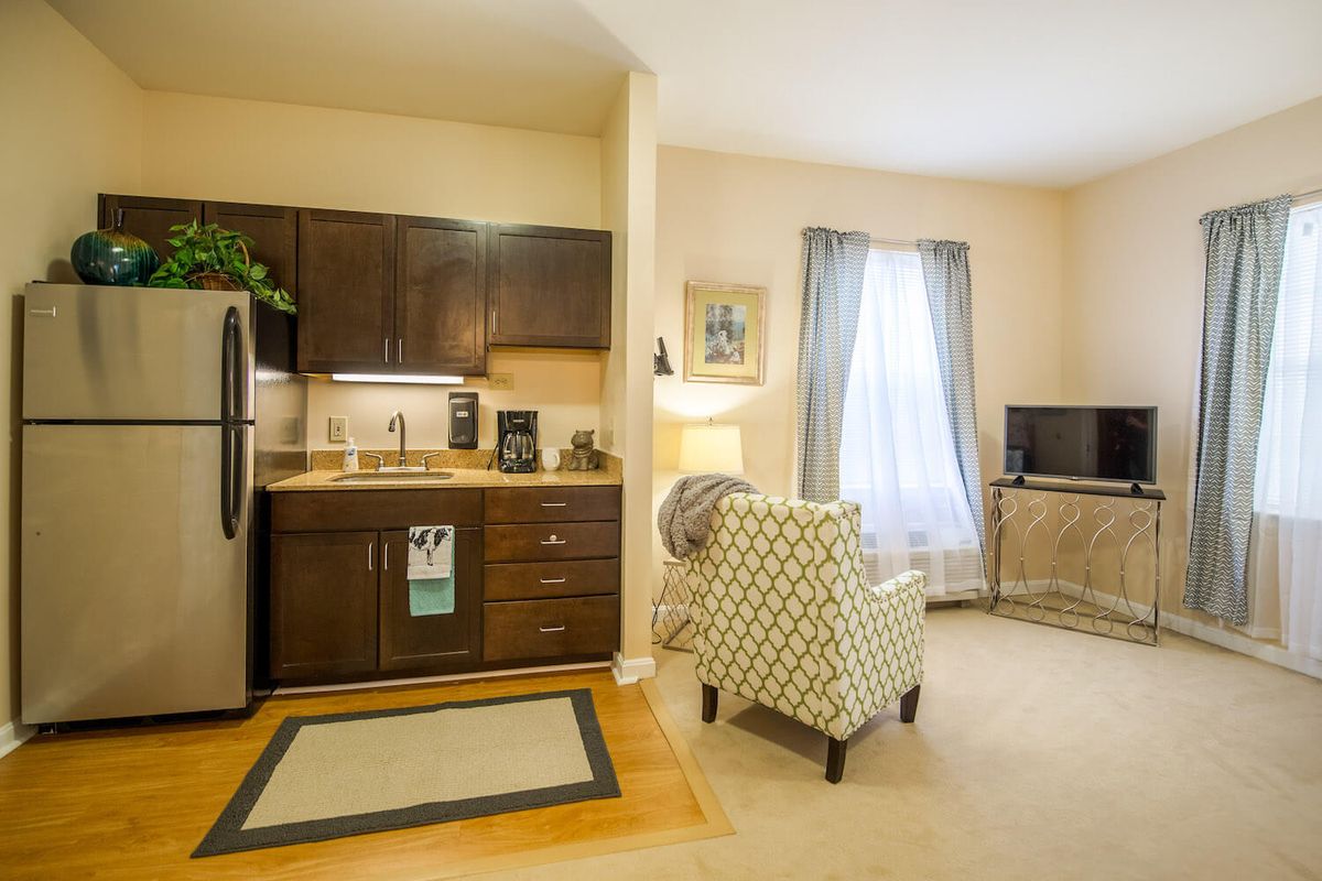 A cozy apartment interior featuring a compact kitchen and a comfortable living area.