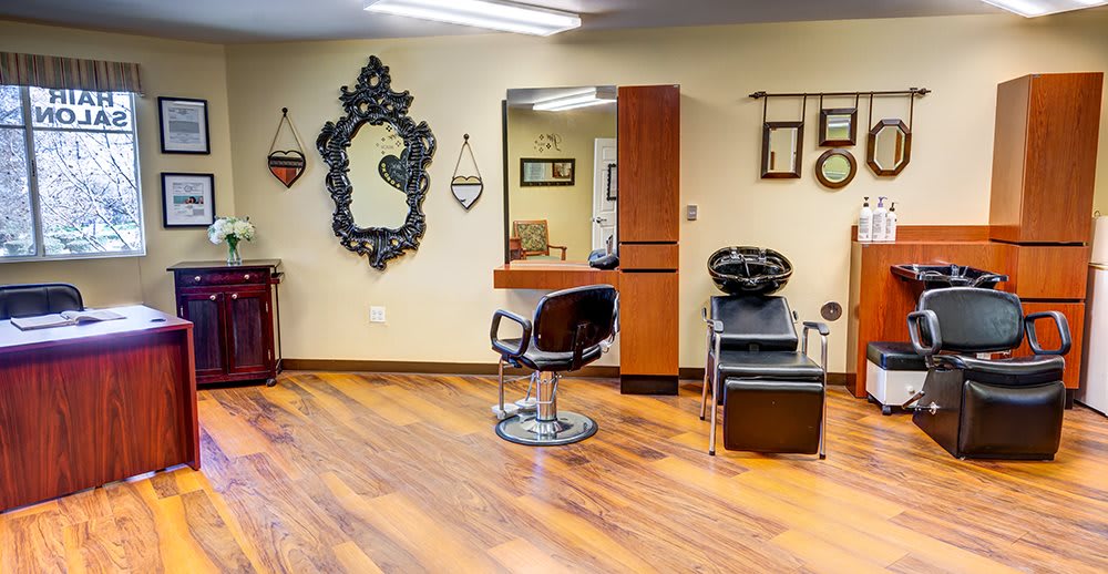 A modern hair salon interior with a styling chair, mirror, and washing station.