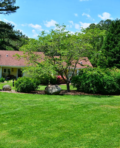 A serene view of a house surrounded by a lush garden and vibrant greenery.