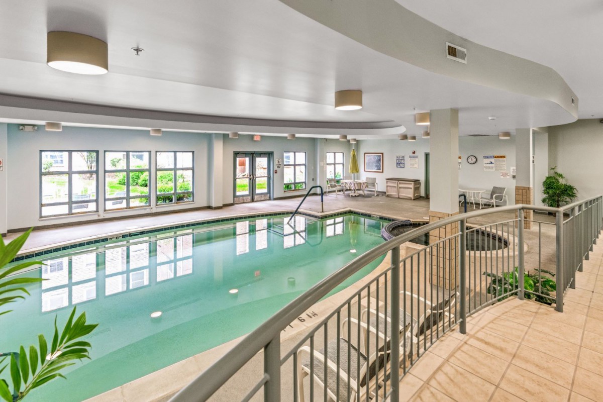 A modern indoor swimming pool with natural lighting and recreational facilities.