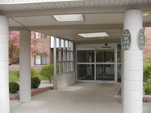 A modern entrance to a building featuring glass doors and a welcoming canopy.