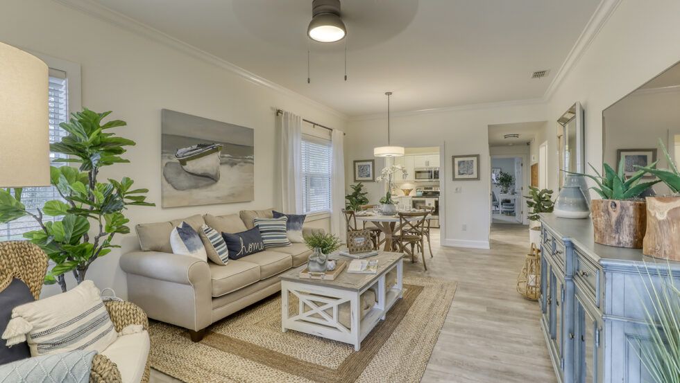 A modern and cozy living room with a neutral color scheme, featuring a sofa and coffee table, and an adjacent dining area.