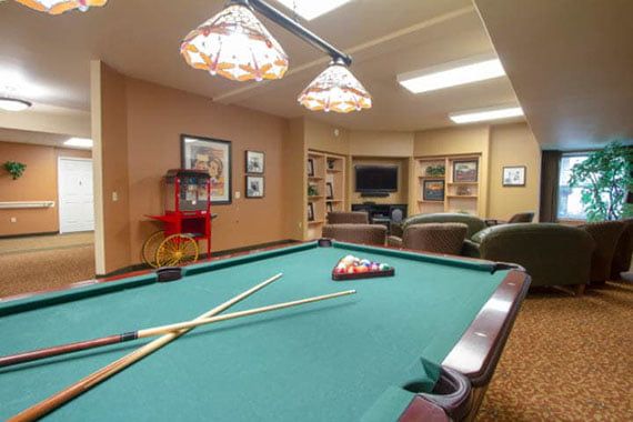 A cozy game room featuring a pool table and comfortable seating.